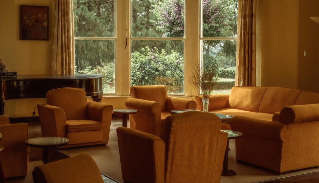 A warm and inviting retro living room featuring vintage furniture and a large window with a scenic view.
