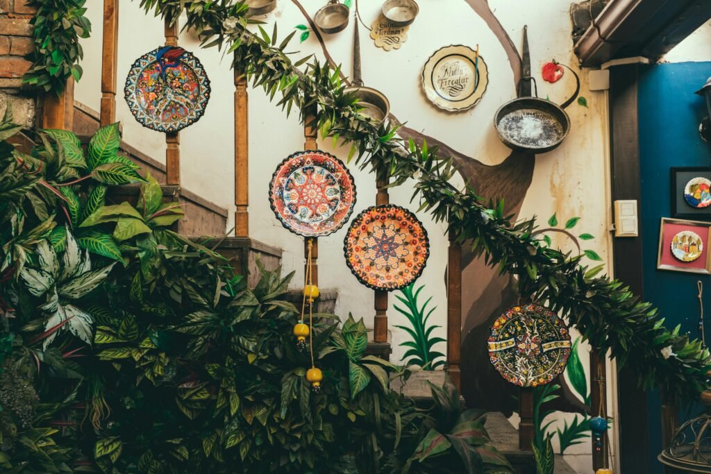 Vibrant patterned plates and lush greenery decorate an indoor stairway for artistic home decor.