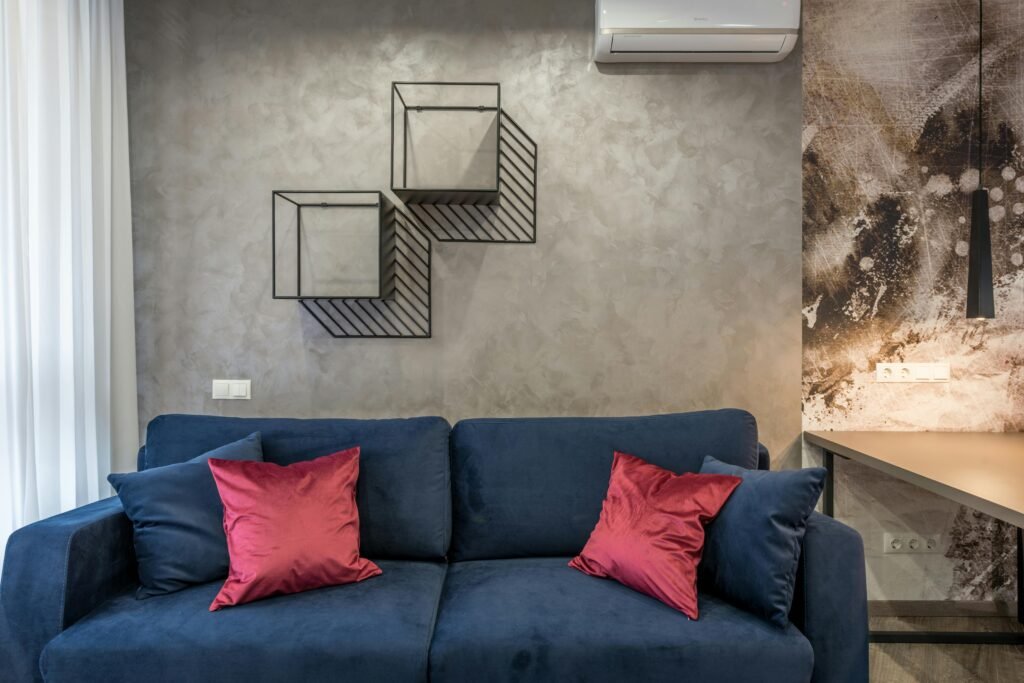 Cozy living room featuring a blue sofa, red pillows, and abstract wall art creating a modern aesthetic.