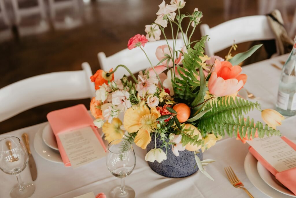 A sophisticated table setting with a vibrant floral centerpiece perfect for weddings or events.
