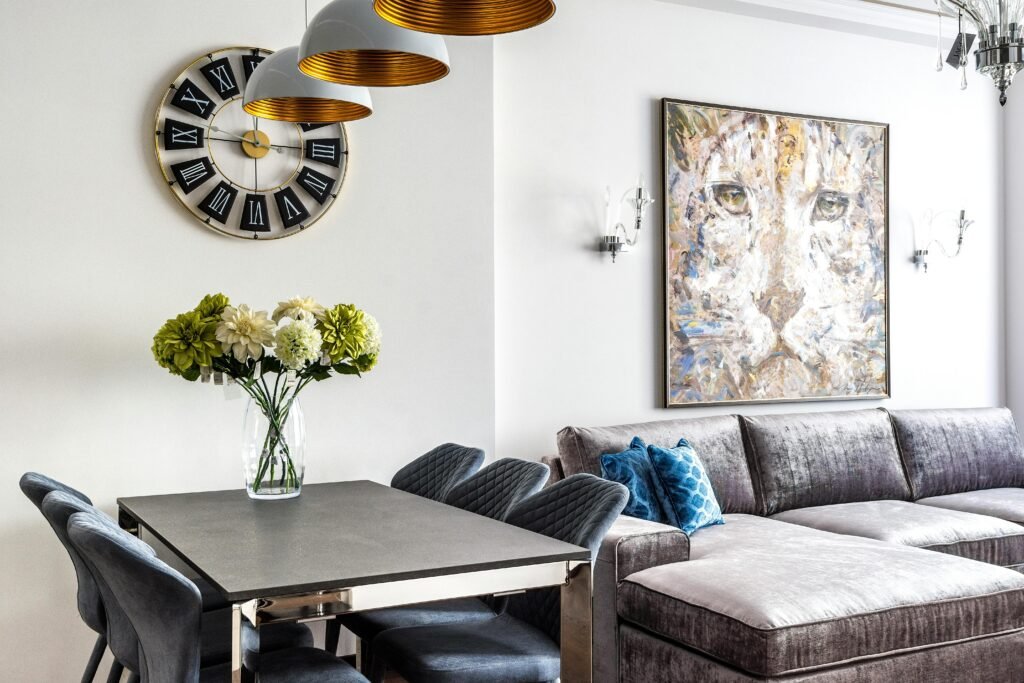 Interior of comfortable modern living room with soft couch with pillows and chairs with table