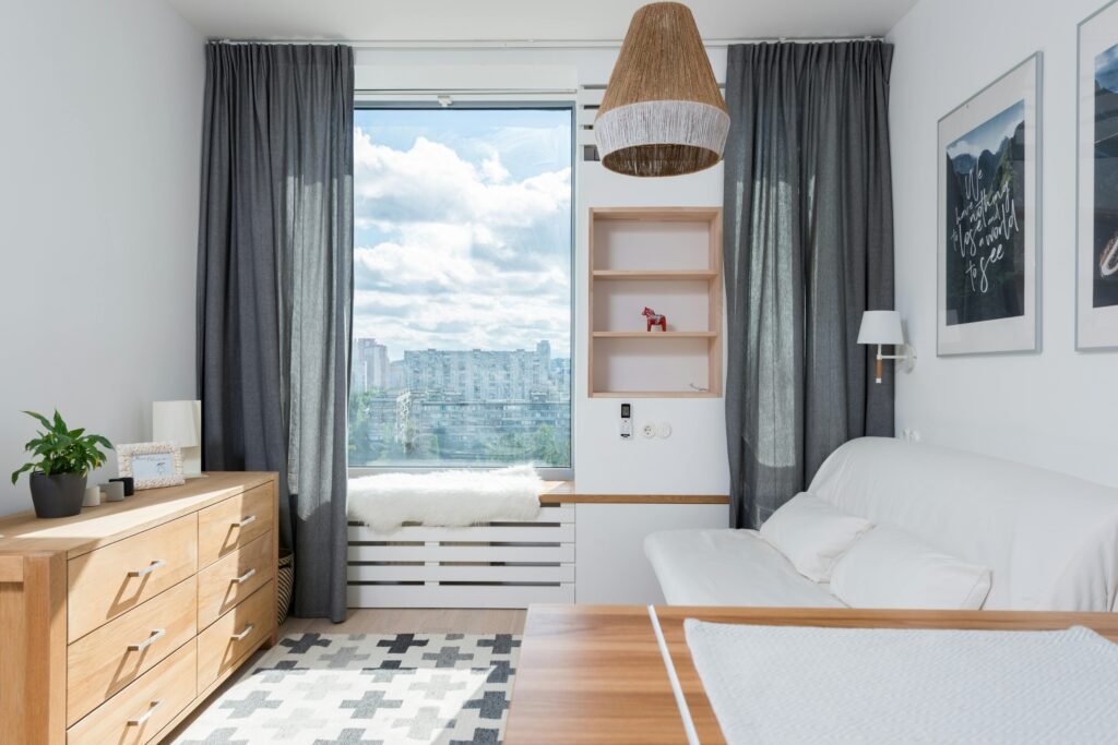 Bright and modern living room with wooden furniture and a large window view.