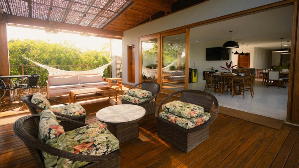 A modern open-plan patio featuring wicker furniture, natural light, and wood decor.